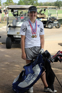 On the course: Emily stands with her medals and golf bag. Photo by Lynn Moore