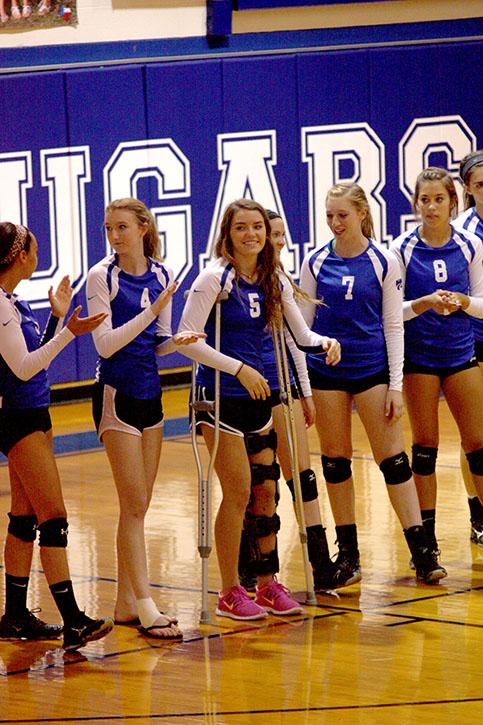 One crutch in front of the other: Junior Varsity volleyball player Ashleigh Teal steps forward when she is recognized before the game starts.