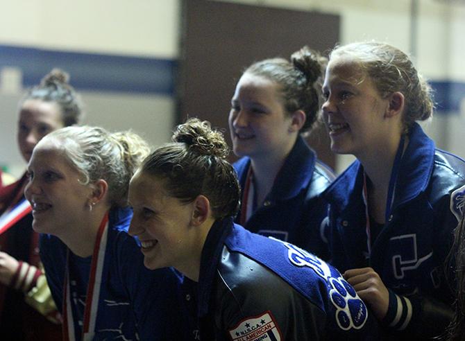 Senior Tori Karker, freshman Sydney Coachman and sophomores Tara Howard and Brandi Courtney pose for pictures on the podium after placing second in the 200m medley relay.