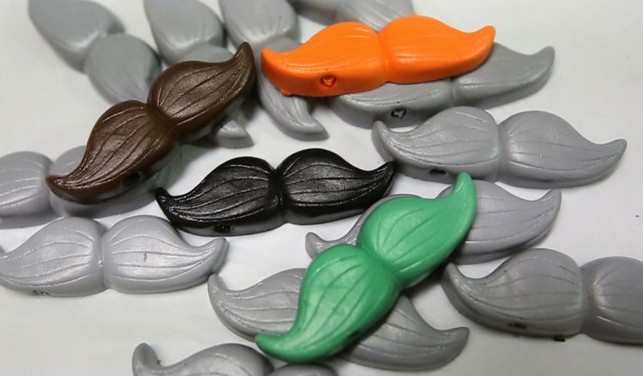 An assortment of different colored plastic mustaches that are produced by Whisker Works in Sanford. Amber and Alex Babcock, co-owners of Whisker Works, have cornered the plastic mustache on a stick market from their Sanford home. (Red Huber/Orlando Sentinel/TNS)