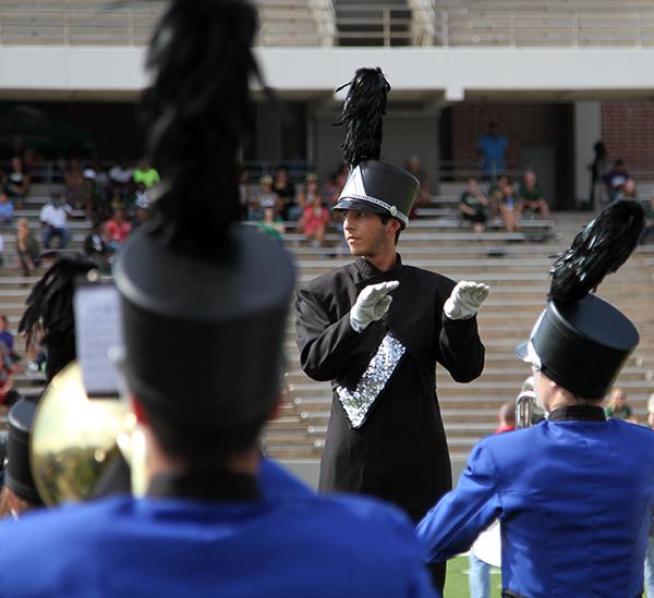 Senior Andres Bryan directs the band during the  halftime performance.