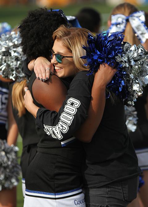 Cheerleaders hug at the conclusion of he last football game.