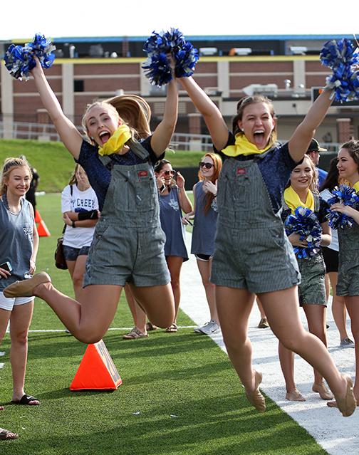 Senior Silvies Erin Roper and Olivia Wilhite jump for a photo before the start of the game.