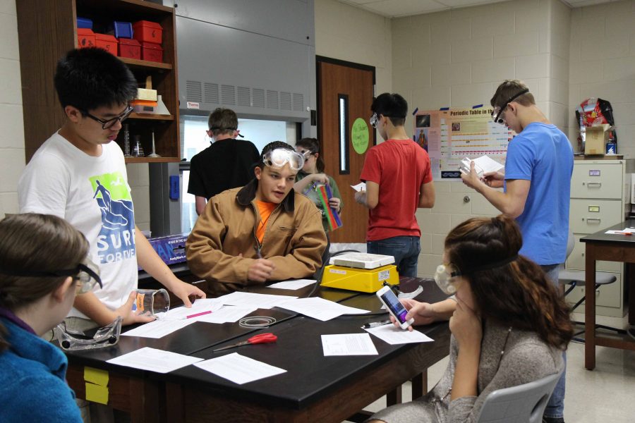 Chemistry+students+gather+around+to+work+on+a+lab