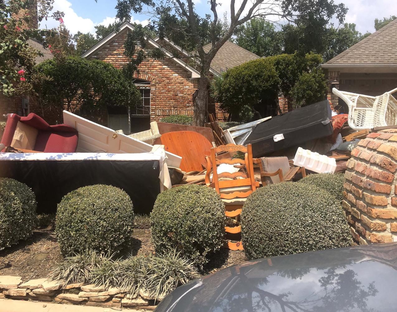 Ruined furniture sits at the curb in front of a flood-damaged home. Dominique McClain volunteered in the community by helping clean out houses.
“There were a couple of neighborhoods not two miles away from me that were just in complete like rambles of devastation,” McClain said. “It looked like the houses threw up everything inside of them on the front lawn.”
