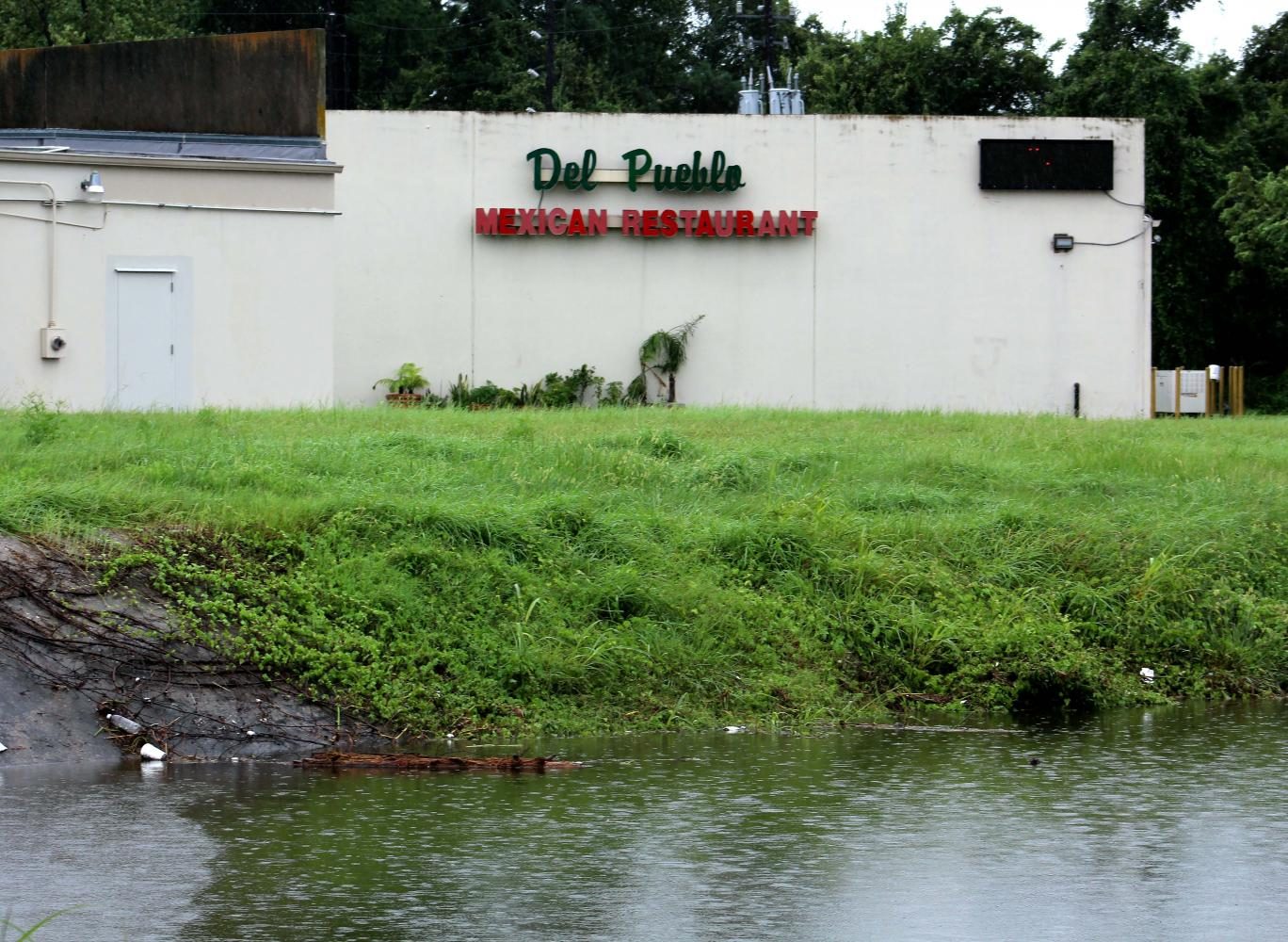 The water levels of Cypress Creek rise behind Del Pueblo on Grant Road.
