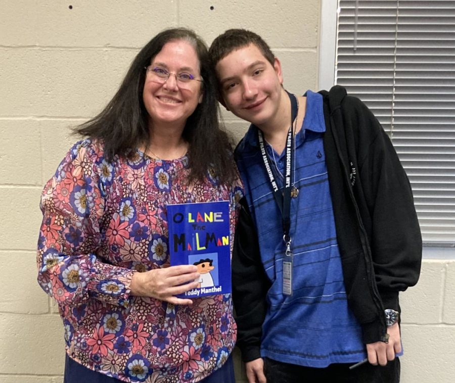 Campus instructional coach Teresa Hughes holding a copy of OLane the Mailman besides Teddy Manthei. Photo courtesy of Teresa Hughes.