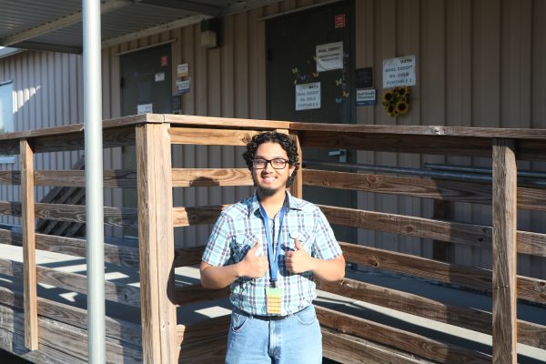 Senior Asiful Huq stands in the sunlight outside the portables.