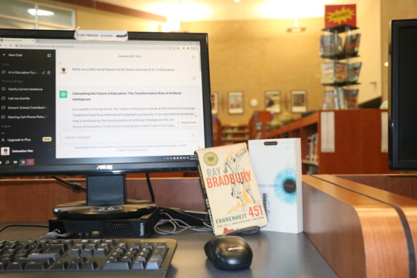 A school computer displaying ChatGPT’s version of this article next to science fiction classics in Cy Creeks library. Photo by Sebastian Mar.