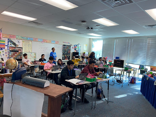 NAC students within the older age group take English. Jennifer Cooksey stands along the whiteboard.